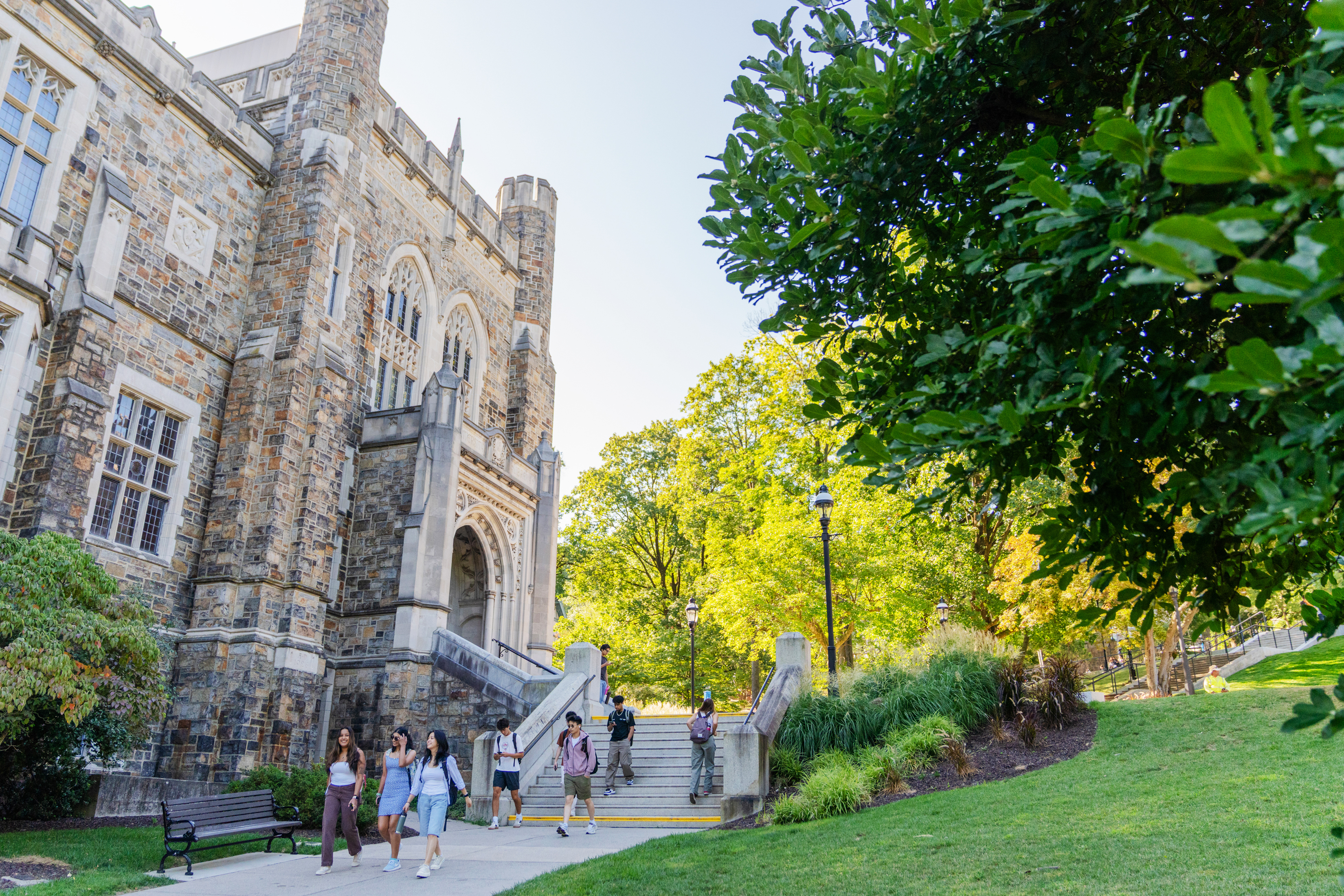students walking outside Linderman Library among the campus tree canopy